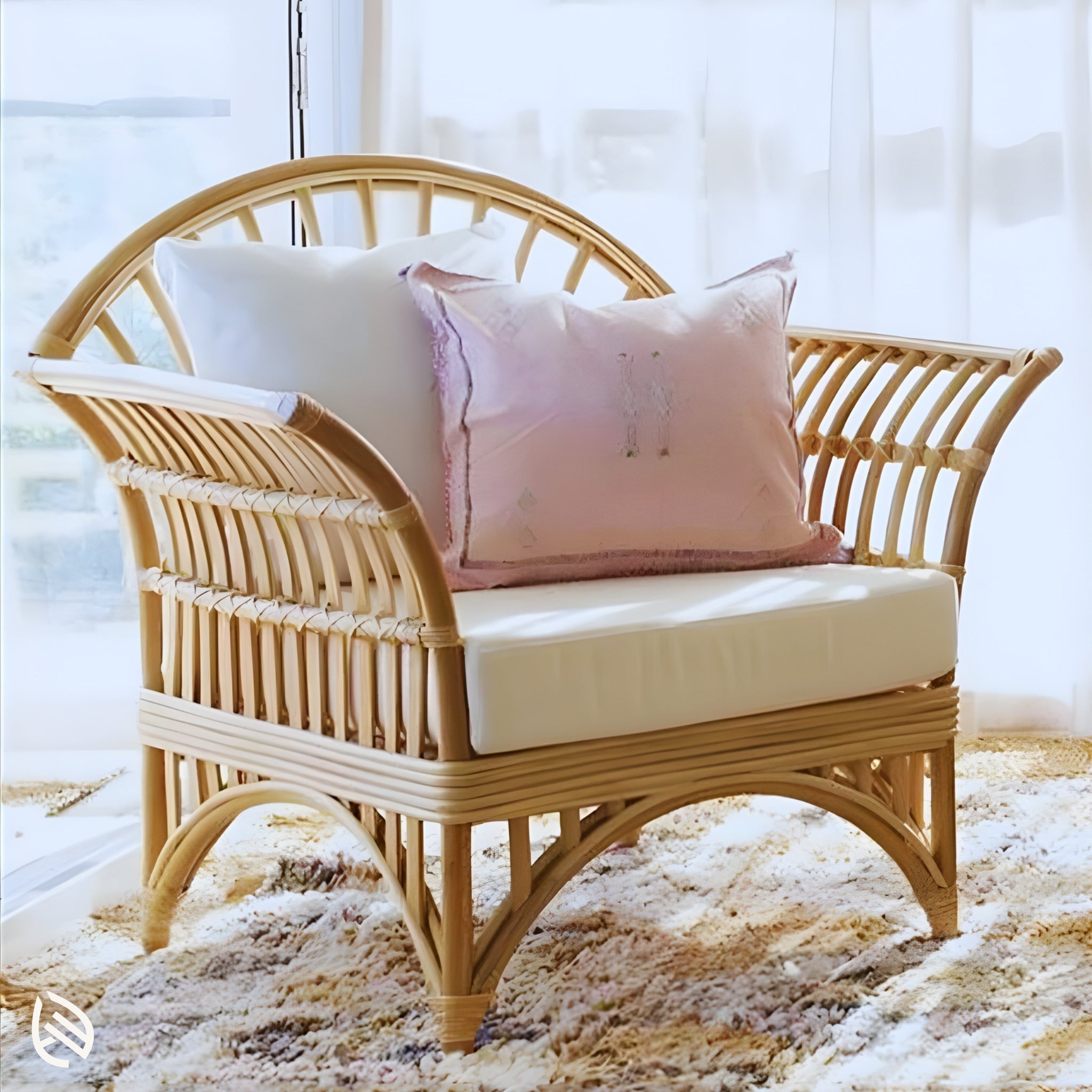 Natural rattan cane chair close-up with plush cushion and blush pillow by window