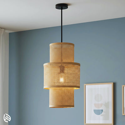 Tall three-tier bamboo lantern pendant against blue wall; natural cane micro-grid, black canopy.