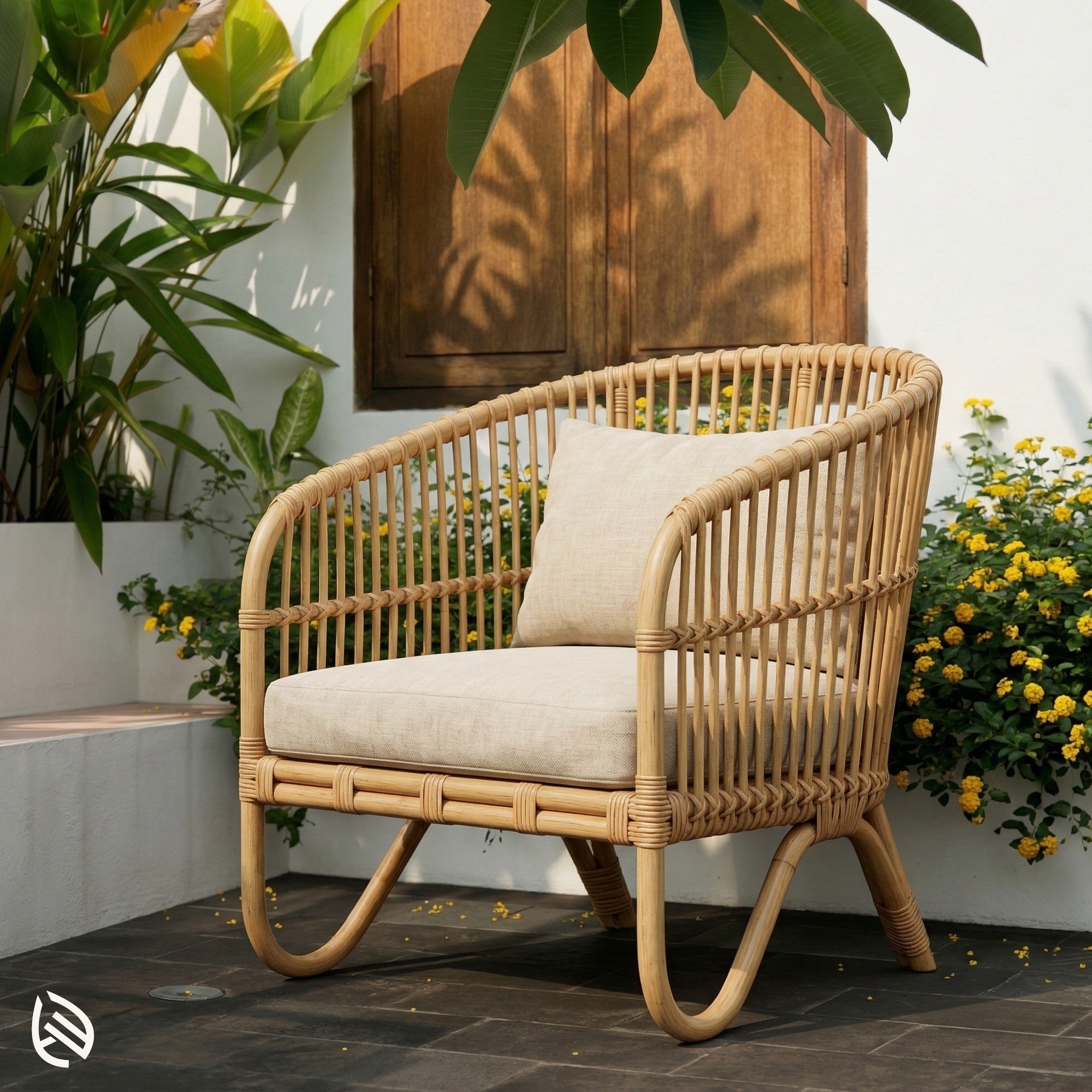 Wicker chair with beige cushion on a patio with plants and flowers