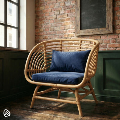 Wicker chair with blue cushions against a brick wall