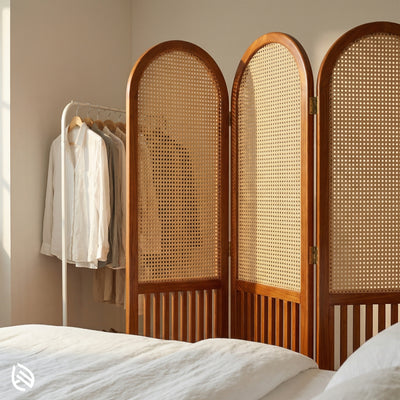 Wooden room divider with wicker panels in a bedroom setting.