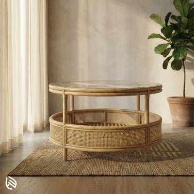 Round wicker coffee table in a room with curtains and a plant