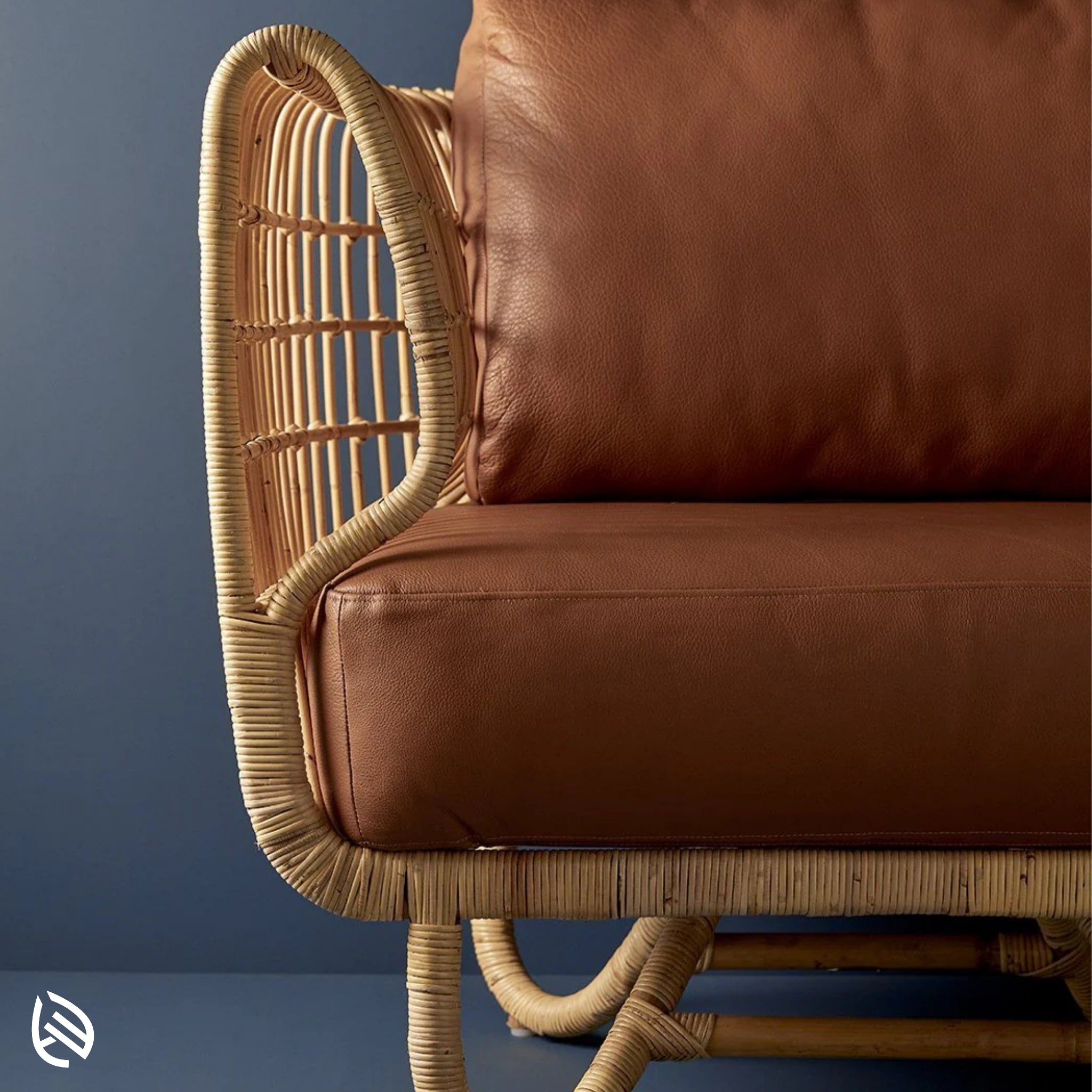 Close-up of curved natural rattan arm and brown leather cushion - detail of Curved Rattan Sofa Set craftsmanship.