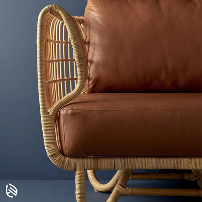 Close-up of curved natural rattan arm and brown leather cushion - detail of Curved Rattan Sofa Set craftsmanship.