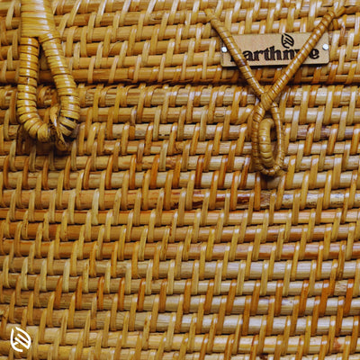Detailed view of EarthNWe brand tag and secure loop lid closure on handwoven rattan basket