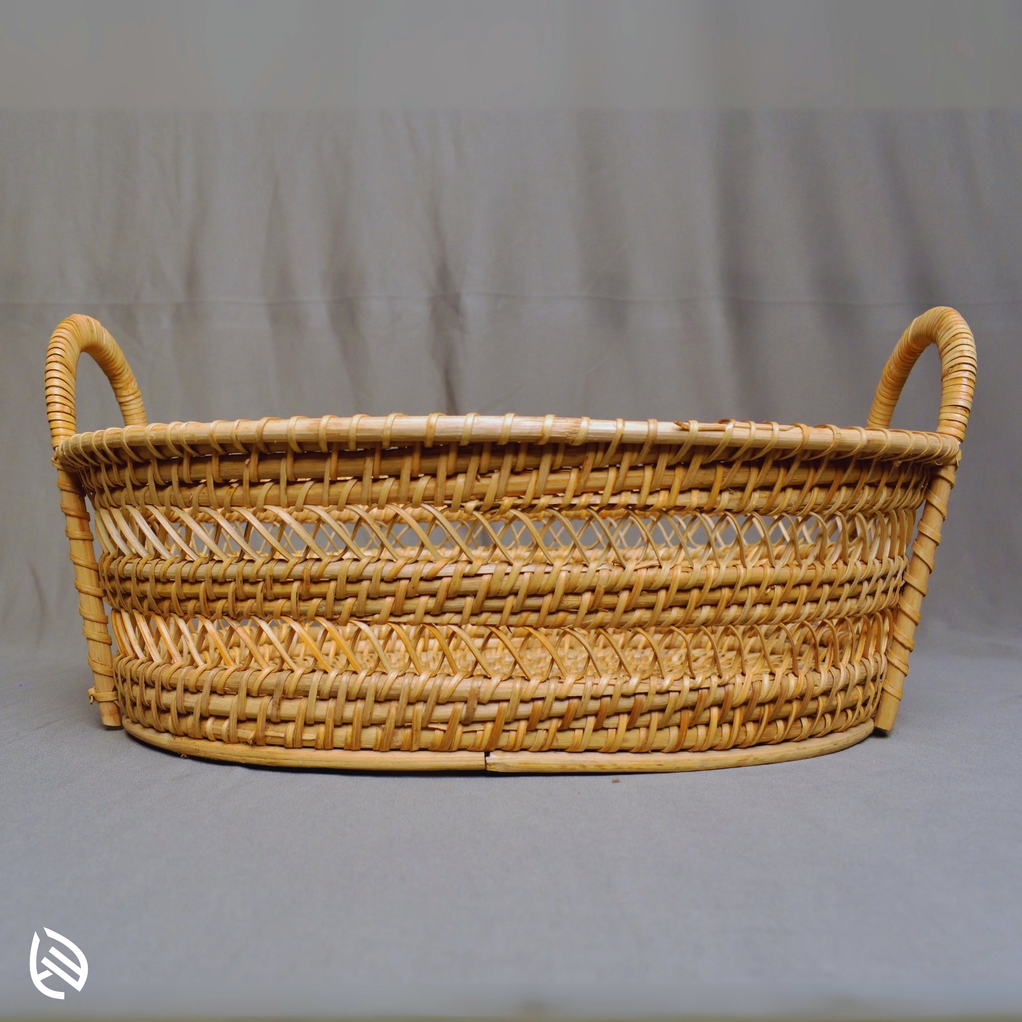 Front view of Drift Stash oval rattan basket with dual loop handles
