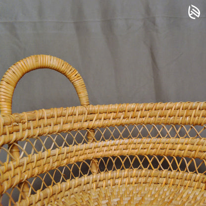 Side detail of Drift Stash basket showing curved rattan handles and mesh weave