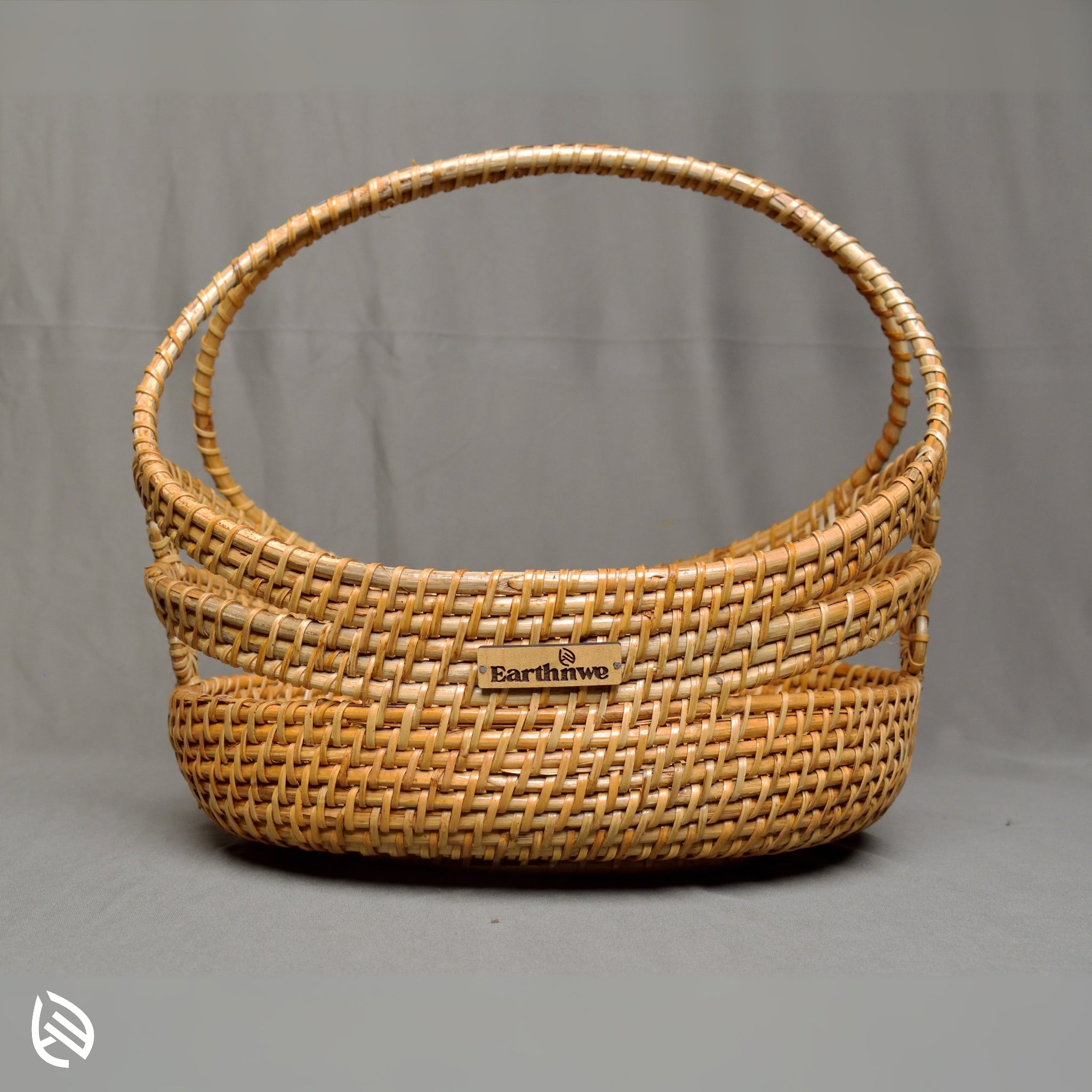 Front view of Stock Keeper oval rattan basket with arch handle and open-rim weave