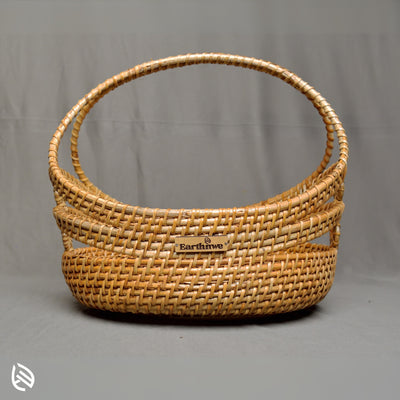 Front view of Stock Keeper oval rattan basket with arch handle and open-rim weave