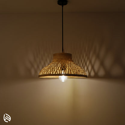 EcoLoom bamboo hanging lamp at night casting lattice shadows; flared cane shade with exposed bulb.