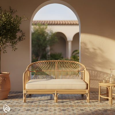 Rattan 2-seater cane sofa under archway, neutral cushion, compact footprint