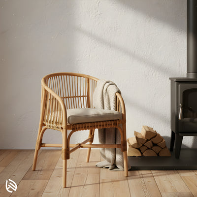 Natural rattan bistro chair by fireplace with cushion and throw