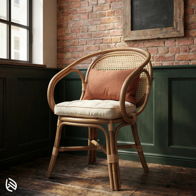 Wicker chair with cushion against a brick wall in a room with green paneling.