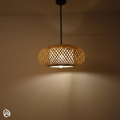 Bamboo pendant light glowing on wall, Oval Cage woven cane shade with warm ambient halo.