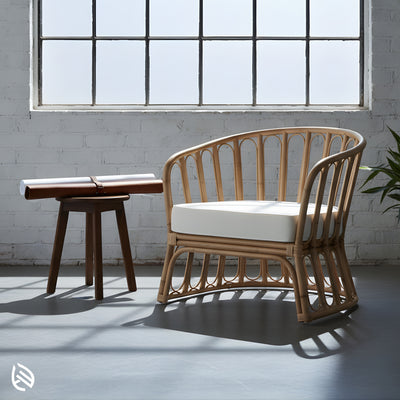 Natural rattan bistro chair by window with cushion and side table