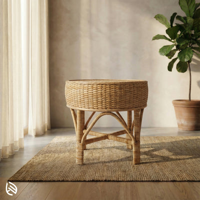 Wicker side table in a room with a plant and curtains