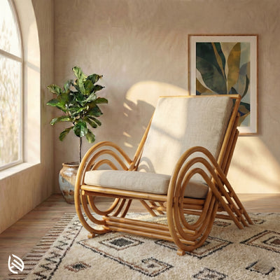Rattan chair with beige cushion in a room with a plant and framed artwork.